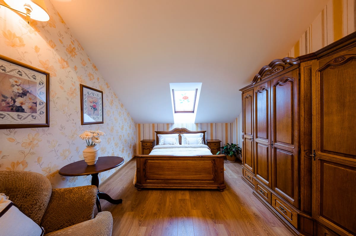 Mansard bedroom with a skylight above the bed and a large oak wardrobe