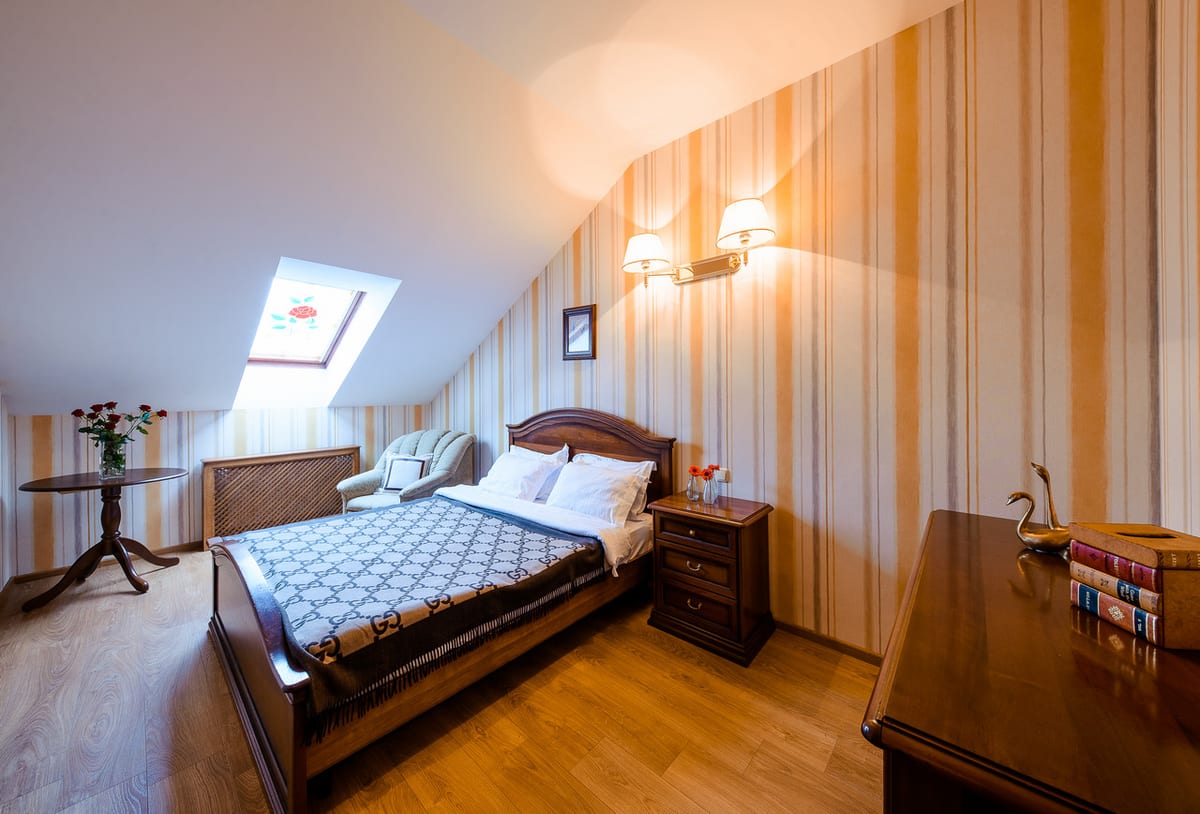 Mansard bedroom with a bistro table under the skylight and a writing desk