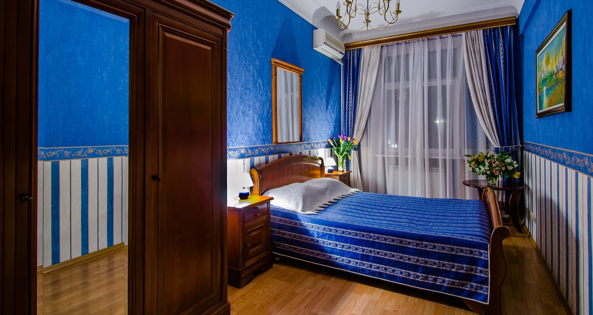 Bedroom with cobalt walls, a striped dado and a blue bedspread