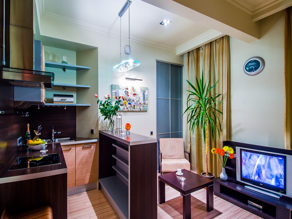 Open-plan kitchen and living room seen wide, dining table beside the seating