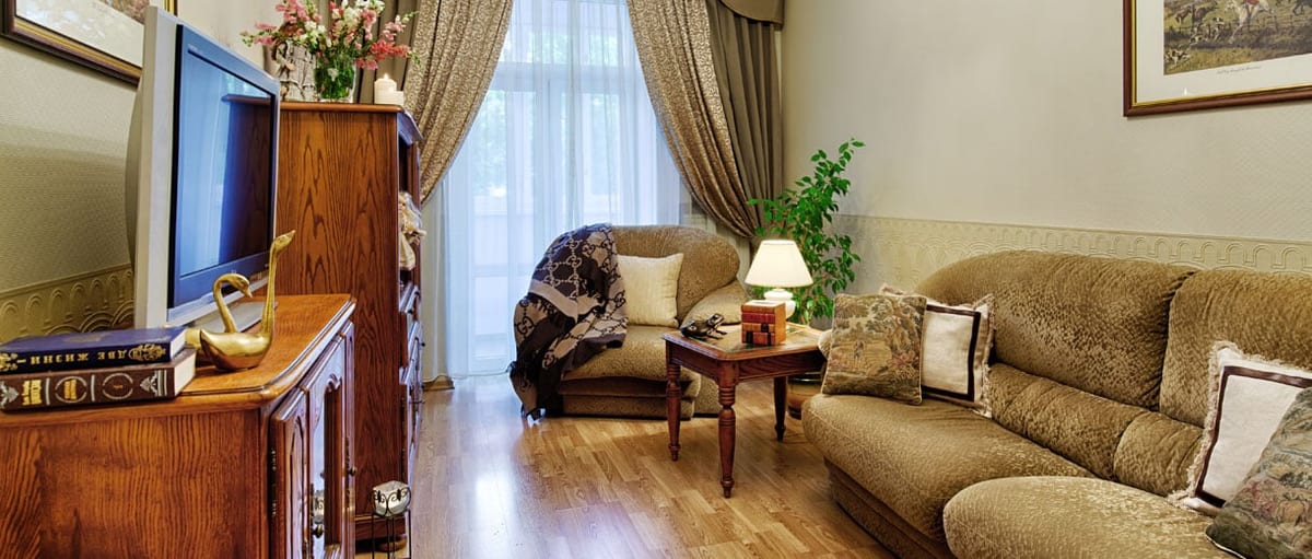 Olive-green sitting room with a television above the low chest