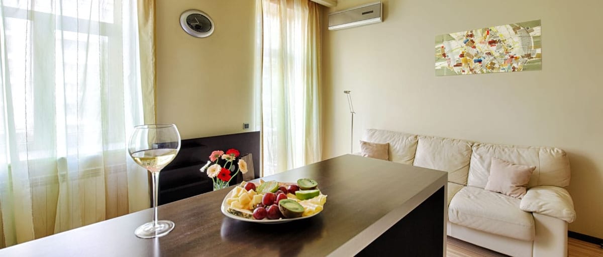 Living room and dining bar set with fruit and a glass of wine