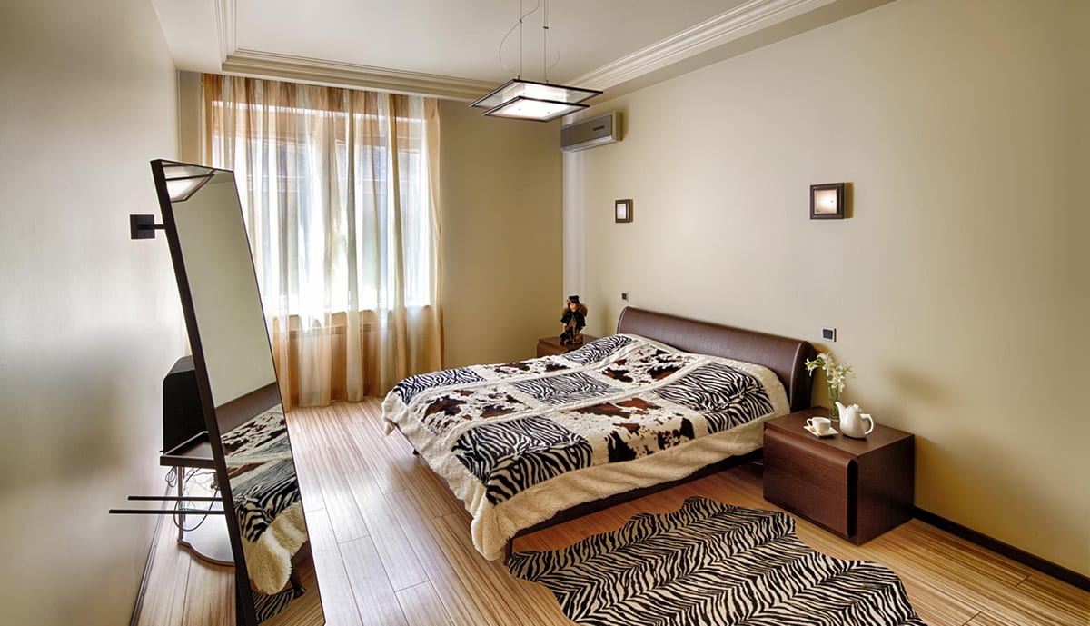 Bedroom with a zebra-print rug and bedspread and a bedside tea tray