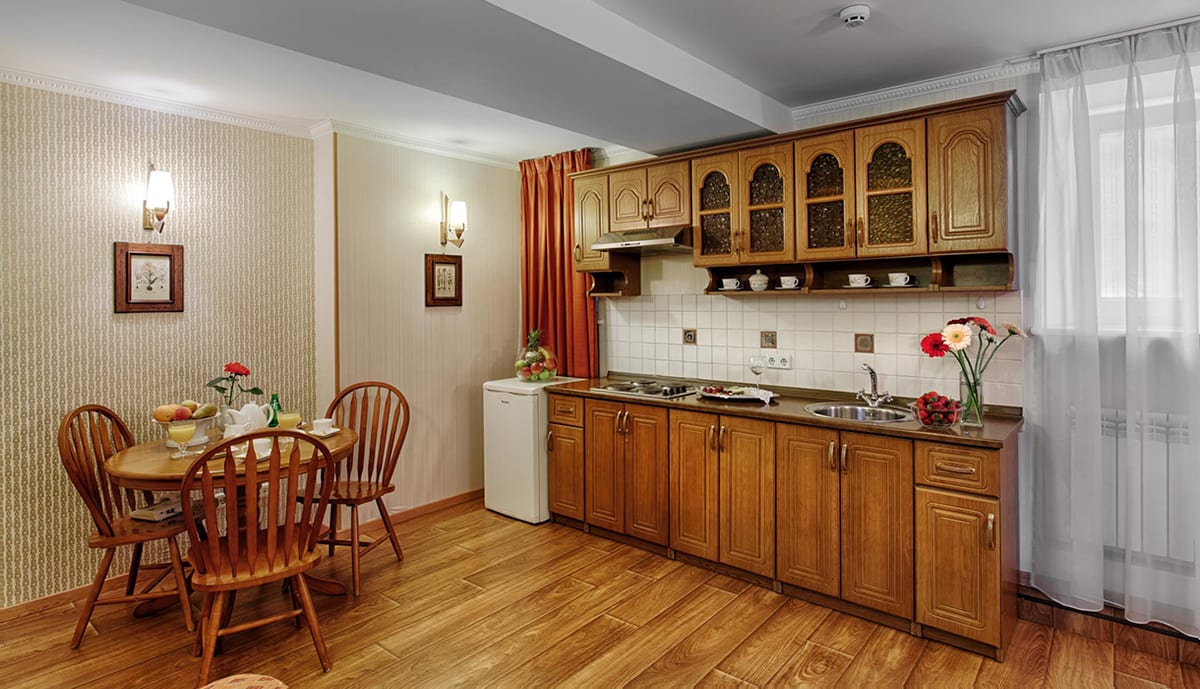 Wooden kitchen with a round dining table and cut carnations