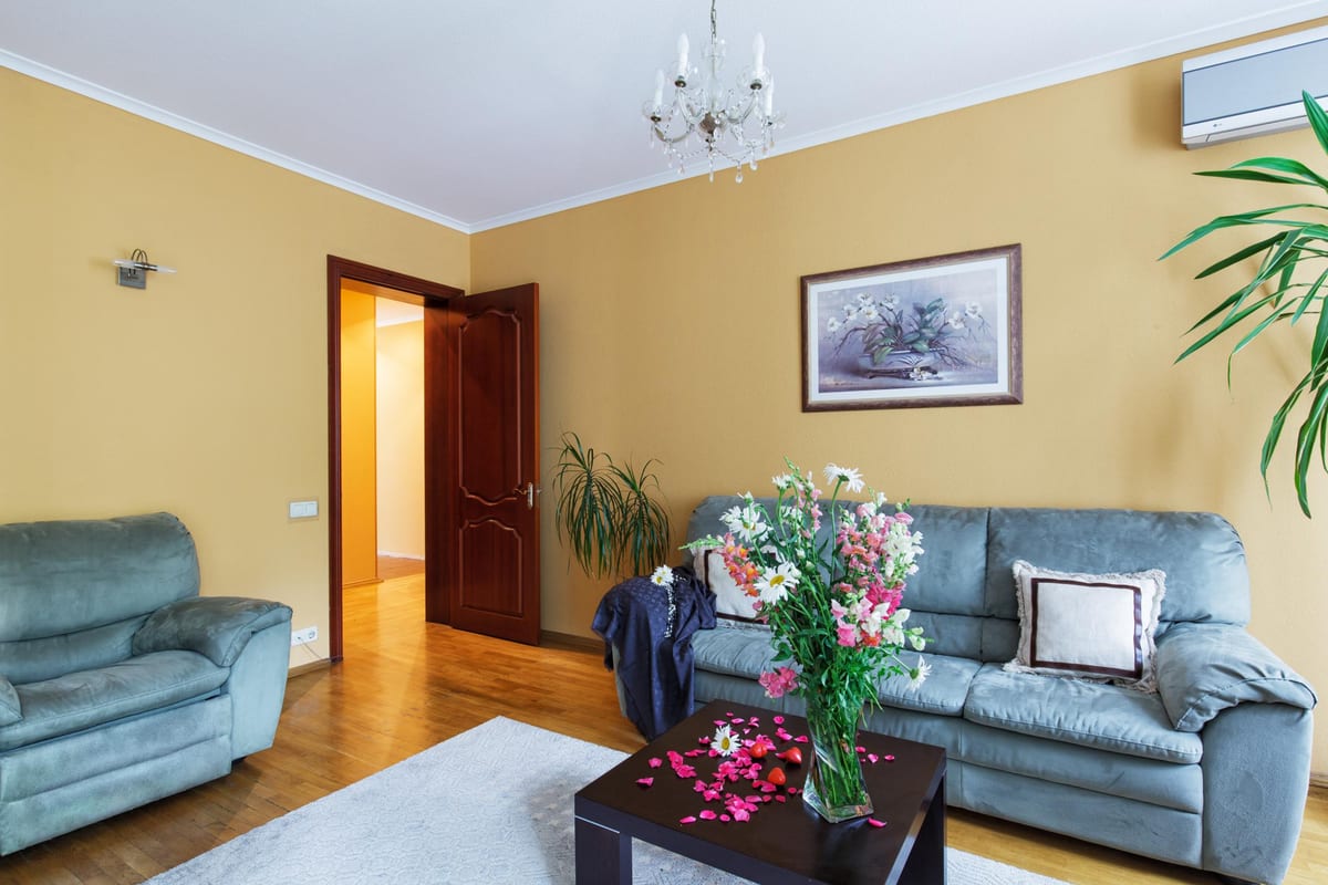 Sitting room with a blue-grey suite, a coffee table and a large bunch of flowers