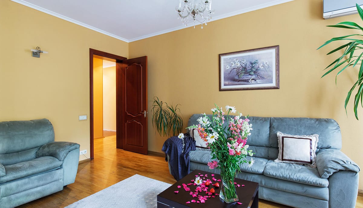 Blue-grey sitting room with a coffee table and a bunch of flowers