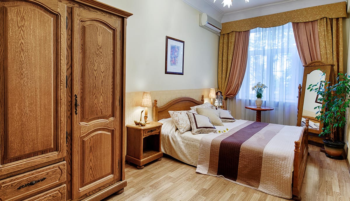 Bedroom with a large oak wardrobe and a cheval mirror beside the bed