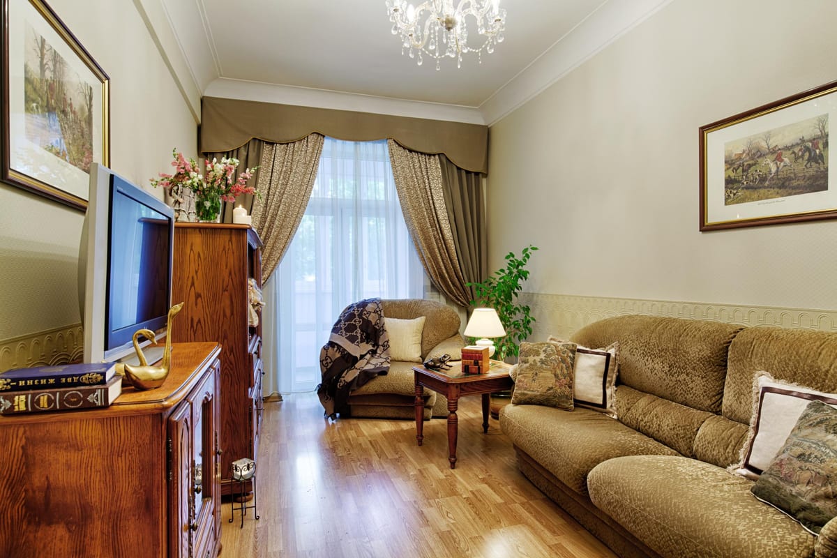 Olive-green sitting room with a sofa, a low table and a television